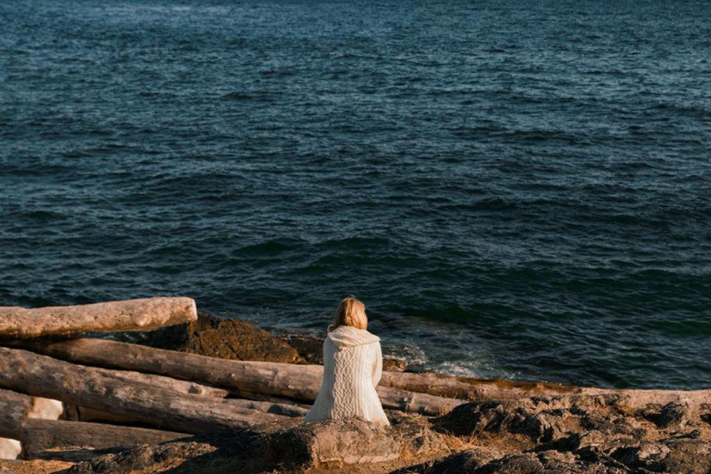 Donna che osserva il mare in solitudine