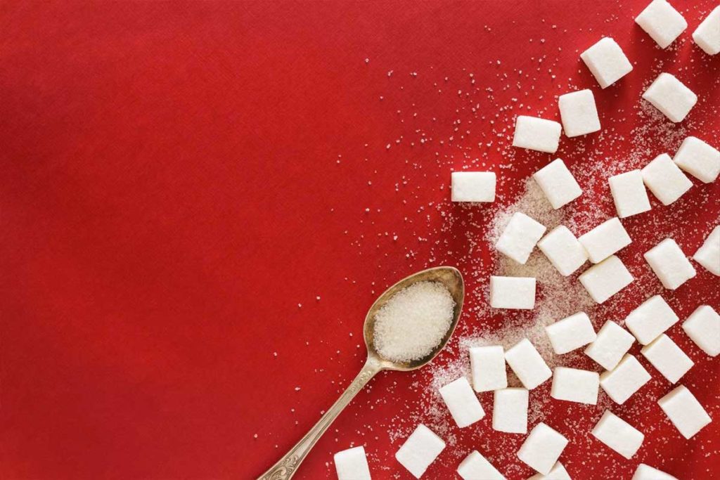 Lo zucchero viene versato su una tavola per dimostrare quanto possa fare male a livello fisico