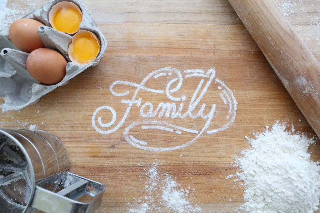 Scritta “Family” con farina su tavolo da cucina.