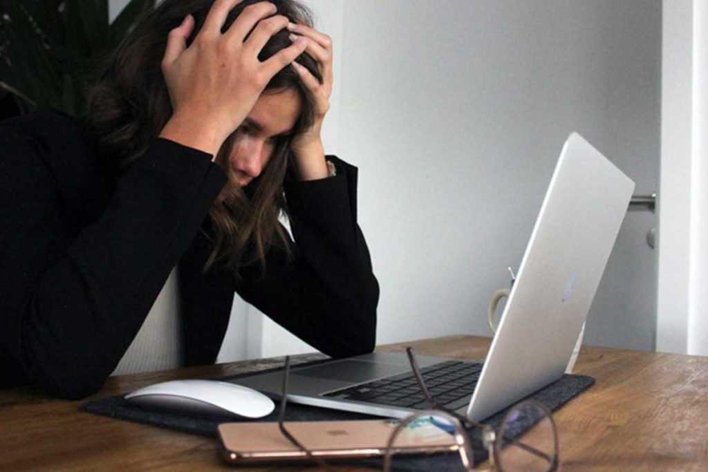 Una donna mostra sintomi da stress per ritorno dalle vacanze mentre è al lavoro