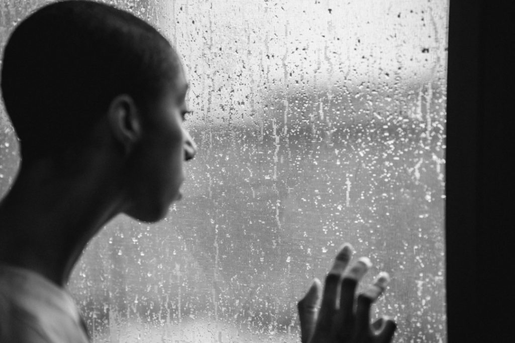 una donna guarda la finestra mentre piove