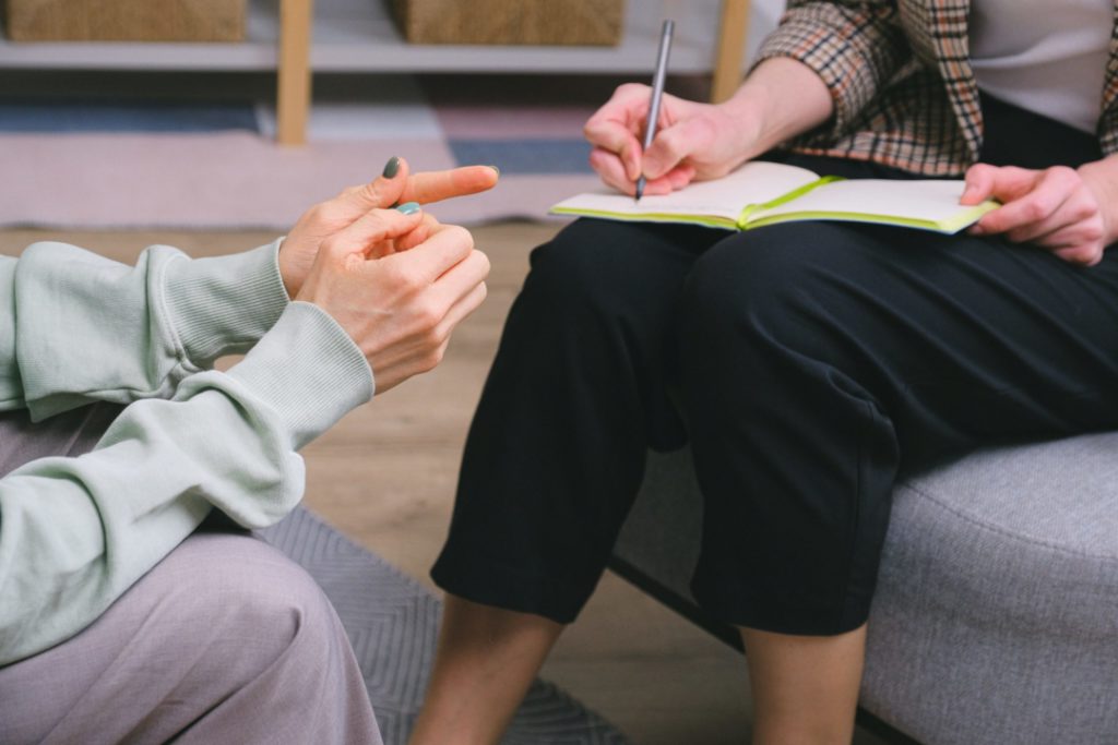 psicologo e paziente seduti uno di fronte all'altro durante una seduta di psicoterapia 