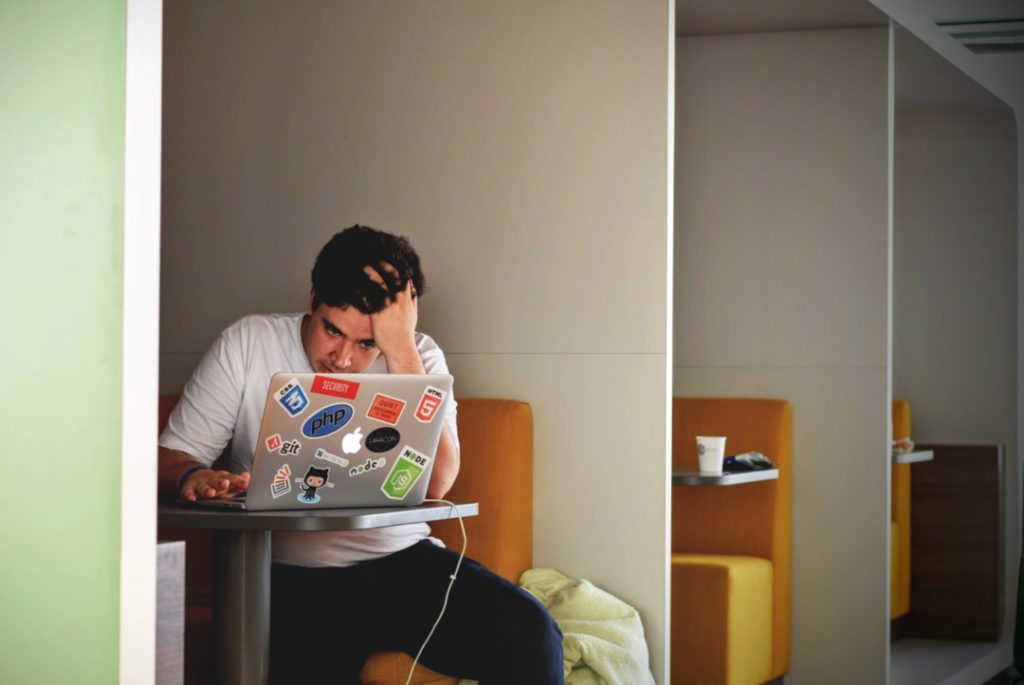 uomo legge al computer con atteggiamento ansioso e stressato