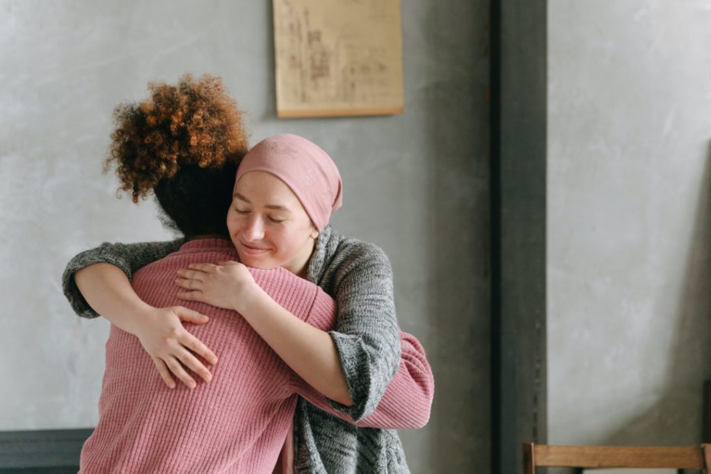 Una donna affetta da tumore abbraccia una sua amica