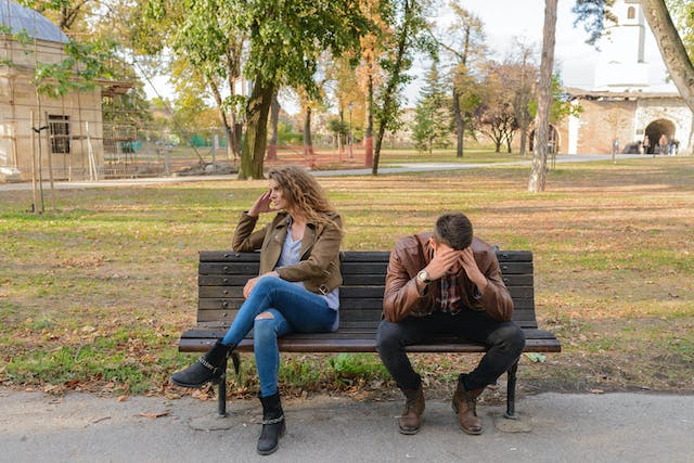 uomo e una donna litigano seduti su una panchina