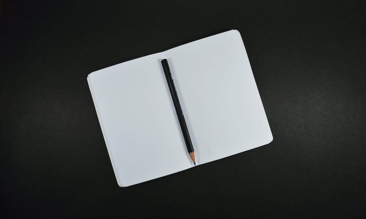 Journaling online: un taccuino nero con matita per annotare i pensieri