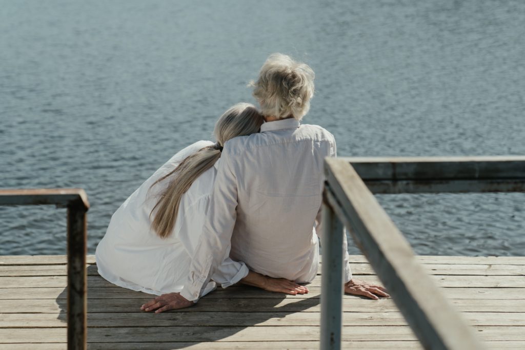 Coppia di uomo e donna maturi si abbracciano e guardano il mare