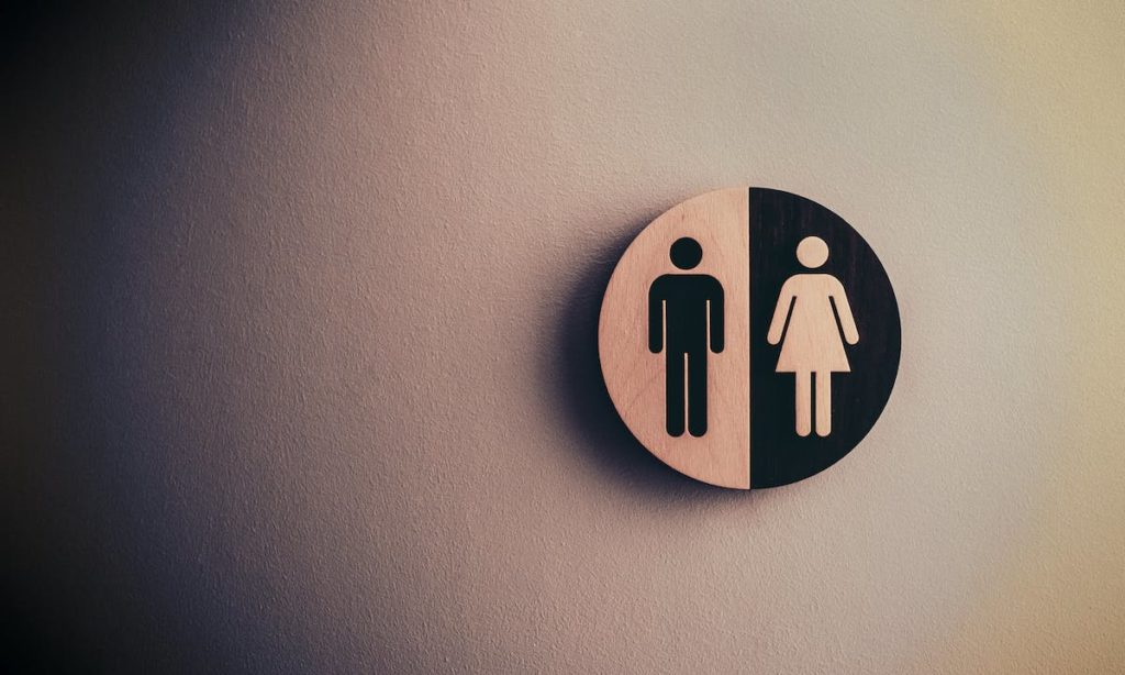 Transizione di genere: loghi uomo donna sulla porta di una toilette