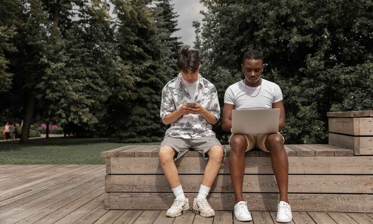 Nomofobia: due ragazzi si informano su laptop e smartphone