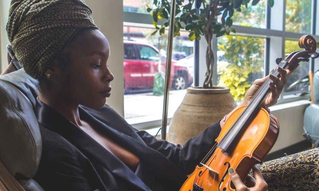 Enneatipo 4: una donna malinconica tiene in mano un violino