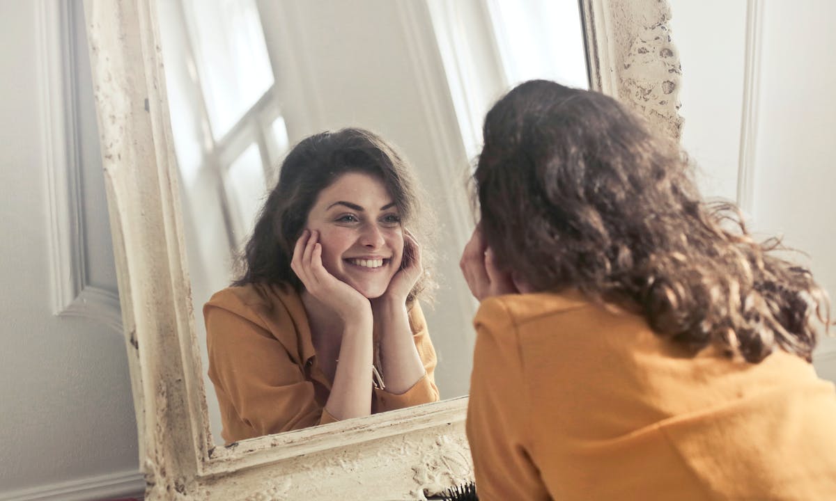 Frasi sul comprendere noi stessi: una donna allo specchio