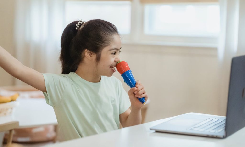 Neurodiversità: una bambina neurodivergente canta di fronte a un computer