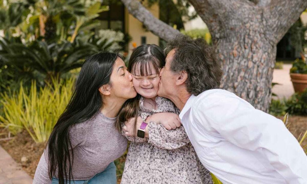 Giornata Mondiale dell'Autismo: i genitori baciano una bimba autistica