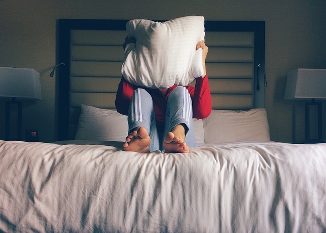 ragazza su un letto con il cuscino sul viso