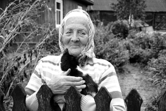 una signora anziana con in braccio un gatto