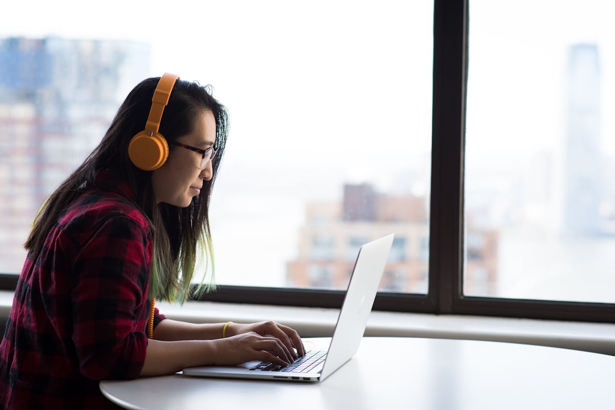 Migliori podcast di psicologia: una ragazza con le cuffie di fronte al computer