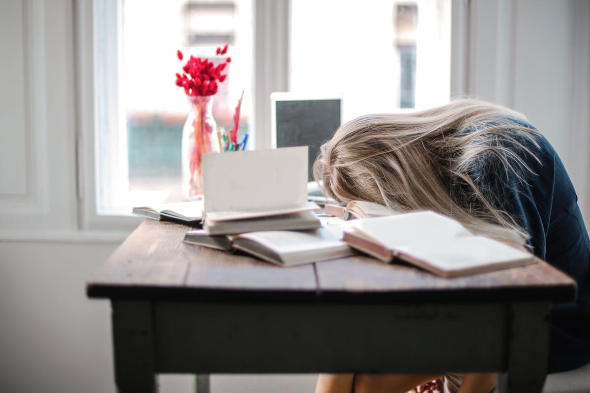 Motivazione: una ragazza addormentata sui suoi libri