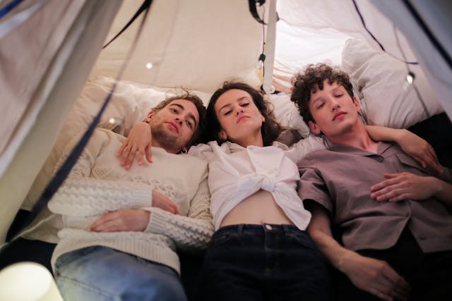 tre ragazzi stesi in una tenda