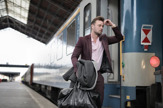 un uomo preoccupato e in ansia vicino a un treno in stazione