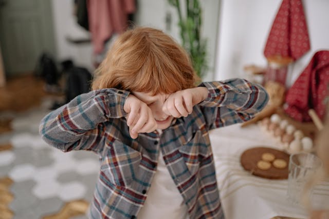 bambino piange e porta le mani al volto