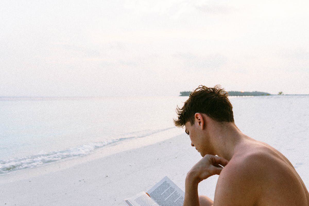 Libroterapia: un ragazzo legge al mare